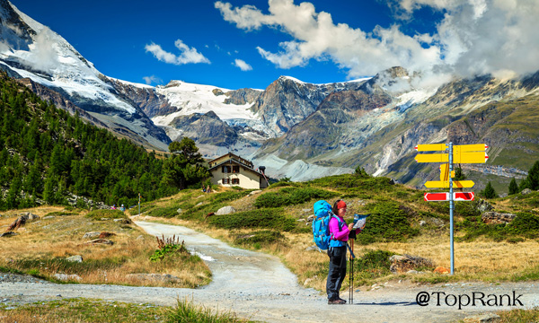 Mountain hiker with map at guideposts.
