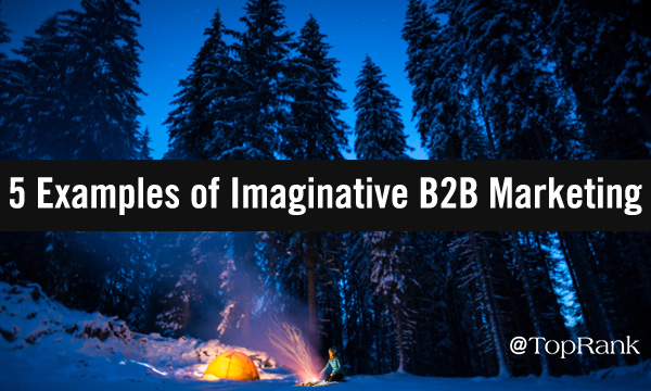 Person by winter campfire and illuminated tent under tall snowy pines.