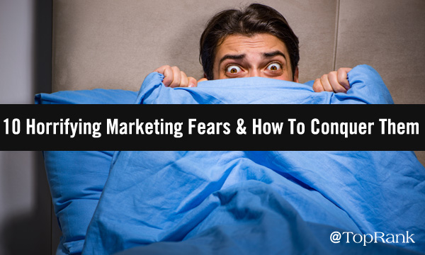 Man cowering in fear behind a blanket.