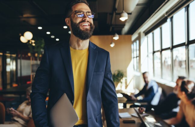 Happy,Young,Businessman,Smiling,In,A,Co-working,Space.,Contemplative,Businessman